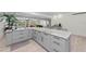 Open concept kitchen with gray cabinets, granite island, and views to pool at 608 69Th W Ave, Bradenton, FL 34207