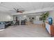 Open living room with kitchen views, L-shaped sectional sofa, and modern ceiling fan at 608 69Th W Ave, Bradenton, FL 34207