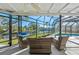 Relaxing screened patio with wicker furniture overlooking pool and canal at 608 69Th W Ave, Bradenton, FL 34207