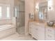Bathroom with a large vanity, a corner soaking tub, and a glass shower at 641 Key Royale Dr, Holmes Beach, FL 34217