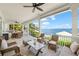 Relaxing covered patio overlooking the water, featuring wicker furniture and ceiling fans at 641 Key Royale Dr, Holmes Beach, FL 34217