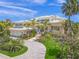Beautiful two-story home with a metal roof, lush landscaping, and circular driveway at 641 Key Royale Dr, Holmes Beach, FL 34217