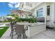 Outdoor kitchen with granite countertops and wicker barstools at 641 Key Royale Dr, Holmes Beach, FL 34217
