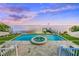 Stunning pool and patio area overlooking the water with built-in fire pit at 641 Key Royale Dr, Holmes Beach, FL 34217