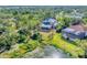 Two homes with pools and screened enclosures, situated on a lush, tree-lined property overlooking a pond at 6779 Ashley Ct, Sarasota, FL 34241