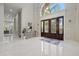 Grand entrance foyer with glossy tiled floors, decorative glass doors, and modern light fixtures at 6779 Ashley Ct, Sarasota, FL 34241