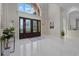 Grand foyer features soaring ceilings, statement chandelier, and decorative glass doors leading to the rest of the home at 6779 Ashley Ct, Sarasota, FL 34241