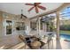 A covered outdoor patio features a seating area, brick floors, and a view of a pool and outdoor kitchen at 6779 Ashley Ct, Sarasota, FL 34241