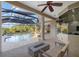 Elegant screened patio with a fireplace, lounge chairs, and view of the pool for refined outdoor living at 6779 Ashley Ct, Sarasota, FL 34241