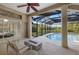 Stylish screened patio area with a fireplace, seating, and a clear view of the pool and tranquil backyard at 6779 Ashley Ct, Sarasota, FL 34241
