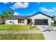 Contemporary home with white and wood accents, landscaped lawn, and a two-car garage at 7516 4Th Avenue Nw Dr, Bradenton, FL 34209