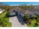 Beautiful single-story home featuring a paver driveway, well-manicured lawn and tropical landscaping at 9908 Carnoustie Pl, Bradenton, FL 34211