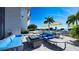 Relaxing patio with blue couches, fire pit, and tables, offering water views at 1155 N Gulfstream Ave # 207, Sarasota, FL 34236