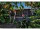 Home's back features a screened porch and lush landscaping with tropical plants at 1460 Landings Cir # 51, Sarasota, FL 34231
