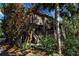 Two-story home with wooden exterior, lush landscaping, and a staircase leading to the entrance at 1460 Landings Cir # 51, Sarasota, FL 34231