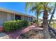 Brick walkway leads to the home's entrance, surrounded by lush landscaping at 174 Venice East Blvd, Venice, FL 34293