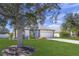 Single-story home with a two-car garage, landscaping, and large tree in front yard at 2419 7Th E Ct, Ellenton, FL 34222