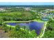 Aerial view of community; showcasing a tranquil lake and surrounding nature at 249 Palmaria Ct, Nokomis, FL 34275