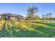 Landscaped backyard with spacious lawn and pond view at 249 Palmaria Ct, Nokomis, FL 34275