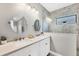 Bright bathroom showcasing a double vanity with quartz countertop, round mirrors, and a marble tiled walk-in shower at 249 Palmaria Ct, Nokomis, FL 34275