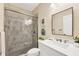 Well-lit bathroom boasts a glass-enclosed shower with marble tiling, modern vanity, and decorative botanical art at 249 Palmaria Ct, Nokomis, FL 34275