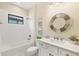Bright bathroom featuring a shower-tub combo with white tiling, a round decorative mirror, and modern vanity at 249 Palmaria Ct, Nokomis, FL 34275