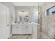 Elegant bathroom featuring a double vanity, modern lighting, and a spacious walk-in shower with marble tile surround at 249 Palmaria Ct, Nokomis, FL 34275