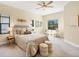 Well-lit bedroom featuring neutral colors, ceiling fan, and comfortable seating area at 249 Palmaria Ct, Nokomis, FL 34275