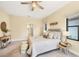 Comfortable bedroom featuring neutral colors, ceiling fan, seating, and natural light at 249 Palmaria Ct, Nokomis, FL 34275
