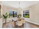 Dining room with a wooden table, upholstered chairs, and natural light coming through the windows at 249 Palmaria Ct, Nokomis, FL 34275