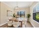 Dining room with a wooden table, upholstered chairs, overhead light fixture and windows with natural light at 249 Palmaria Ct, Nokomis, FL 34275