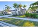 A beautiful home exterior with a well-manicured lawn, driveway, and tall palm trees at 249 Palmaria Ct, Nokomis, FL 34275