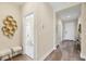 Hallway with hardwood floors leads to a bathroom with marble floors and modern fixtures at 249 Palmaria Ct, Nokomis, FL 34275