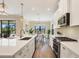 Modern kitchen featuring stainless steel appliances, a large island, and an adjacent dining area with natural light at 249 Palmaria Ct, Nokomis, FL 34275
