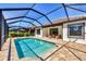 Private backyard oasis featuring a sparkling pool, brick patio, and a screened-in lanai at 249 Palmaria Ct, Nokomis, FL 34275