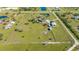 Aerial view of home and property, highlighting acreage with multiple structures and horse riding circle at 25205 67Th E Ave, Myakka City, FL 34251