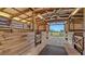 Well-maintained horse barn with stalls, overhead lighting, and a view of the surrounding property at 25205 67Th E Ave, Myakka City, FL 34251