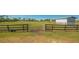 Grassy field with an open gate, leading into a spacious and well-maintained horse property or farm at 25205 67Th E Ave, Myakka City, FL 34251