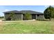 Charming single-story home has a well-manicured lawn and landscaping with flowering plants along the walkway at 25205 67Th E Ave, Myakka City, FL 34251