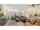 Open-concept living room featuring a large sectional, fireplace, and seamless access to the kitchen at 25205 67Th E Ave, Myakka City, FL 34251