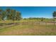 Fenced grassy pasture with scattered trees, providing a safe and natural environment for horses to graze at 25205 67Th E Ave, Myakka City, FL 34251