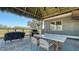 Outdoor dining and cooking area featuring a grill and comfortable seating under a tiki roof at 25205 67Th E Ave, Myakka City, FL 34251