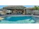 Backyard pool and patio, complete with a tiki bar, lounge chairs and a dining area, ideal for outdoor gatherings at 25205 67Th E Ave, Myakka City, FL 34251