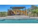 Relaxing lounge area with modern pergola by the pool, featuring comfortable seating and a serene waterfall feature at 25205 67Th E Ave, Myakka City, FL 34251