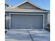 Two-car garage with gray siding and a concrete driveway at 4042 Kingsfield Dr, Parrish, FL 34219