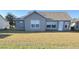 Rear view of house with gray siding and lawn at 4042 Kingsfield Dr, Parrish, FL 34219