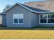 Gray house exterior with white windows. The house has a shingled roof and is surrounded by a grassy lawn at 4042 Kingsfield Dr, Parrish, FL 34219