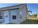 Gray house exterior with white trim, windows, and door. The house has a shingled roof and is surrounded by a grassy lawn at 4042 Kingsfield Dr, Parrish, FL 34219