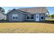 Rear view of house with gray siding and lawn at 4042 Kingsfield Dr, Parrish, FL 34219