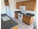 Galley kitchen with wood cabinets, granite countertops, and white appliances at 4042 Kingsfield Dr, Parrish, FL 34219